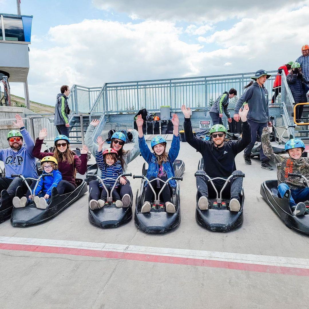 A group of friends raise their hands in the air ready to ride the tracks at Downhill Karting Calgary.