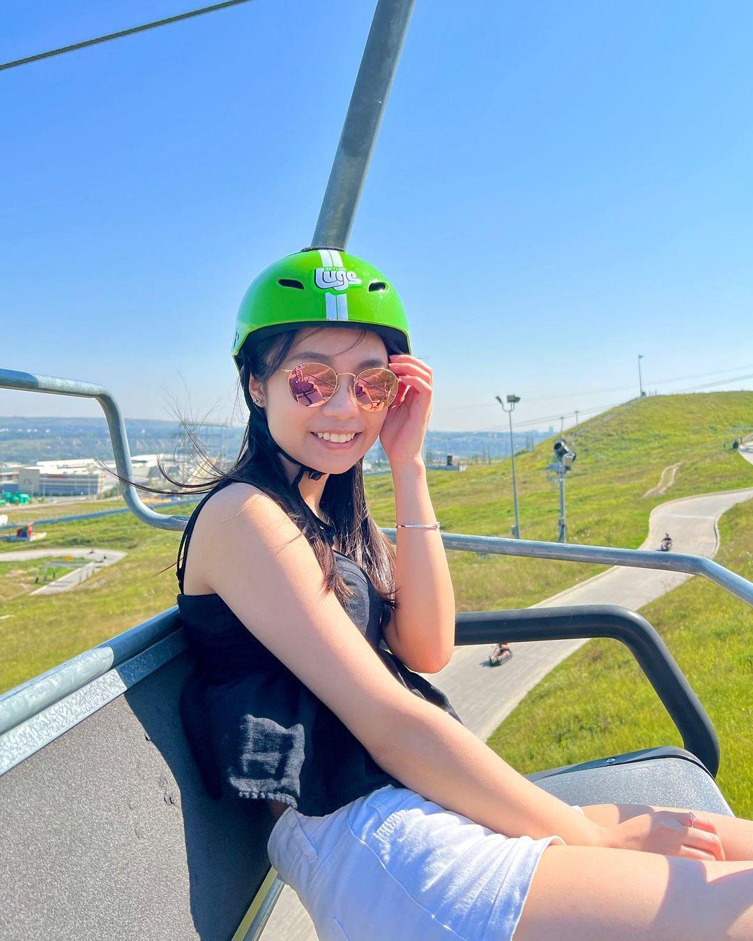 A woman poses for a photo on the Downhill Karting Calgary chairlift.