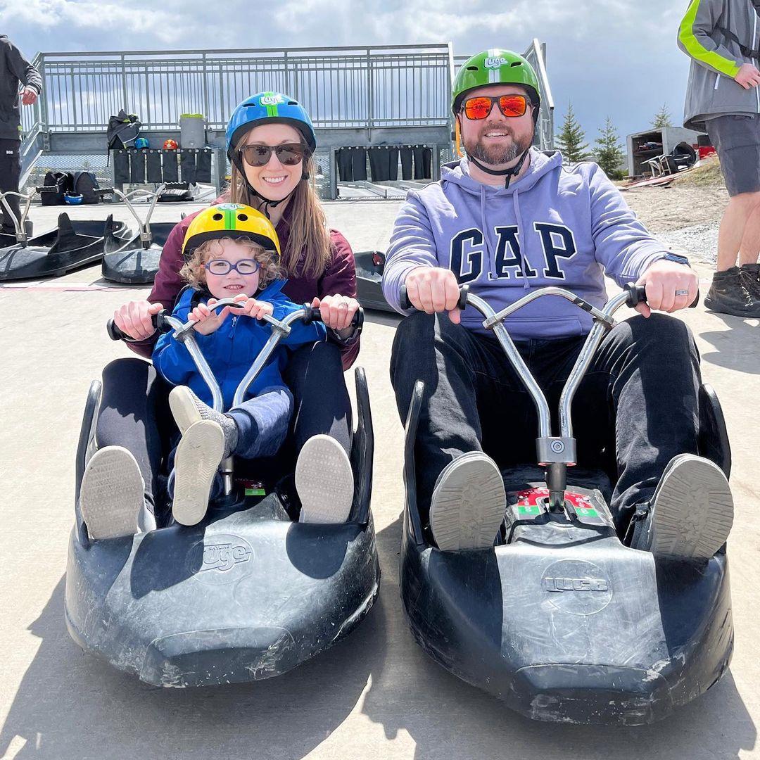 A mother and father prepare to ride the track with their kids in the same cart at Downhill Karting Calgary.