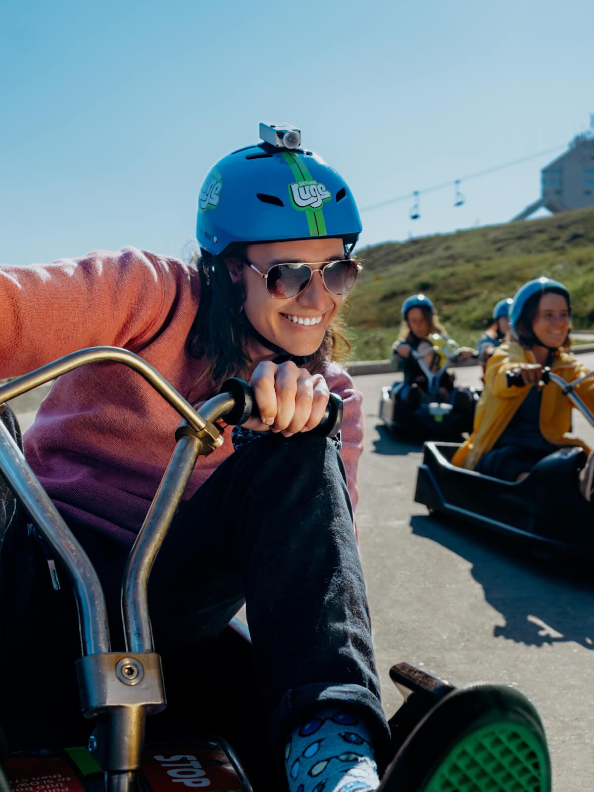 A lady smiles as she rides round a corner skilfully at Downhill Karting Calgary.